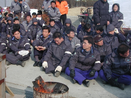 배달호씨가 근무했던 보일러 공장 조합원들이 시신 옆에 앉아서 비통한 모습을 하고 있다. 